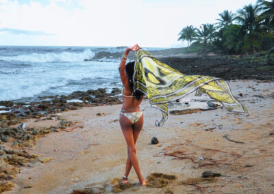 Elise Hart on a beach with a scarf blowing the wind
